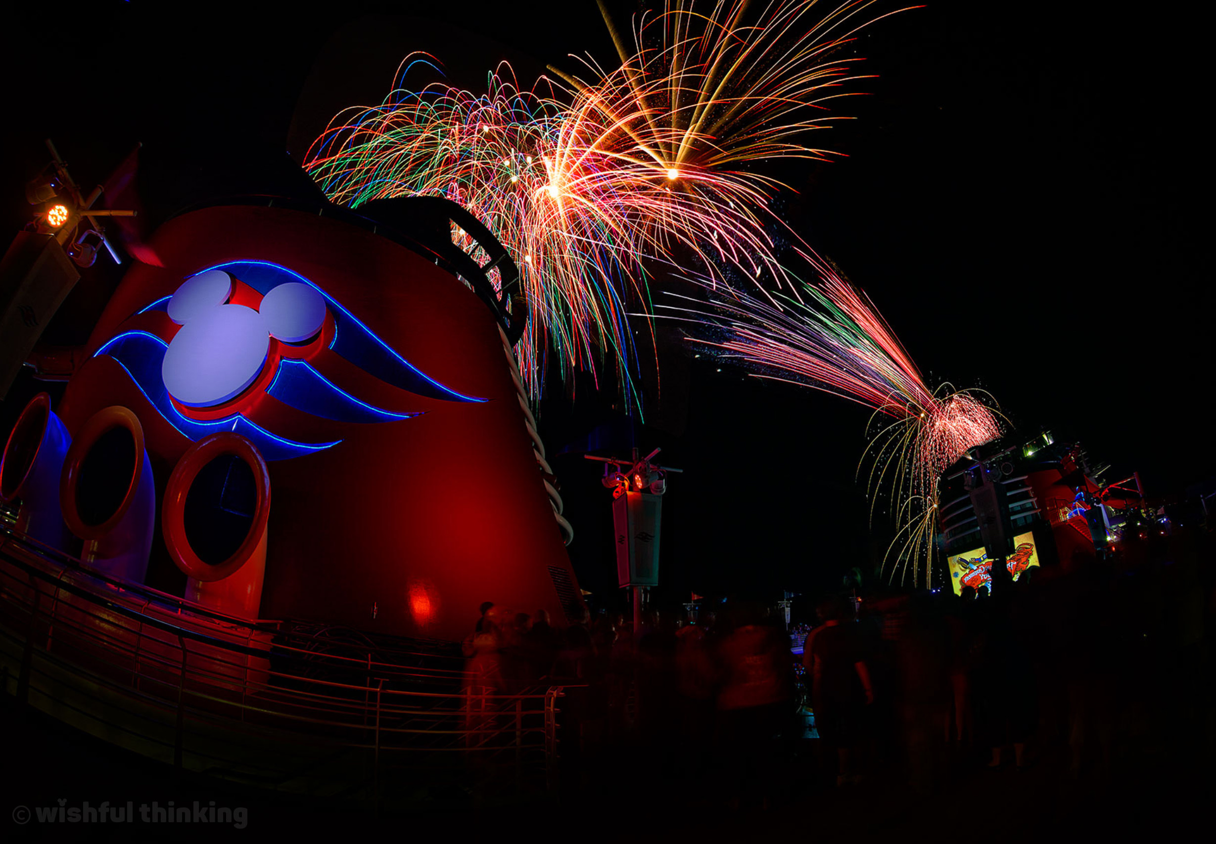 Firworks illuminate the sky over guests on board a Disney Cruise Line ship