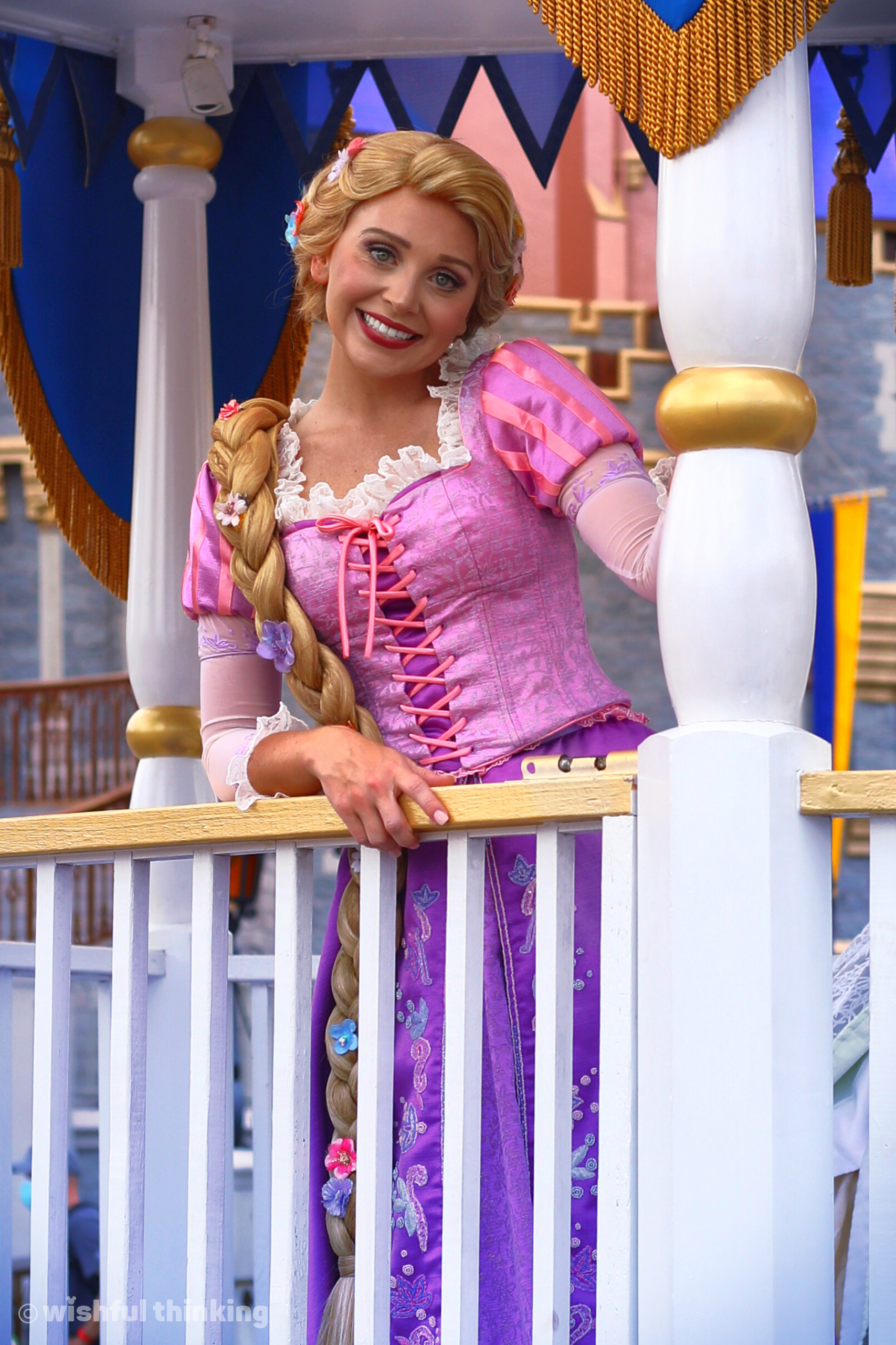 Rapunzel smiles from a passing character cavalcade in Walt Disney World's Magic Kingdom