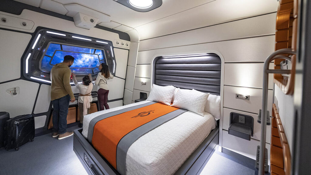 Guests look out the window in the Halcyon standard cabin aboard the Star Wars Galactic Starcruiser