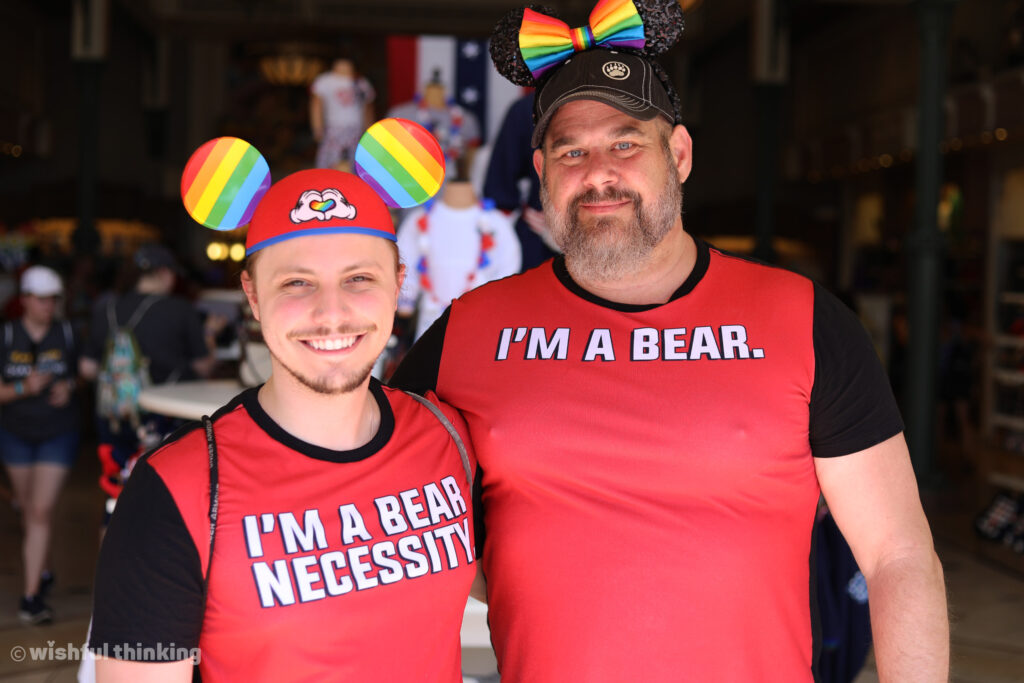 At Gay Days, two men wear humorous shirts saying I'm A Bear and I'm a Bear Necessity at Magic Kingdom at Walt Disney World