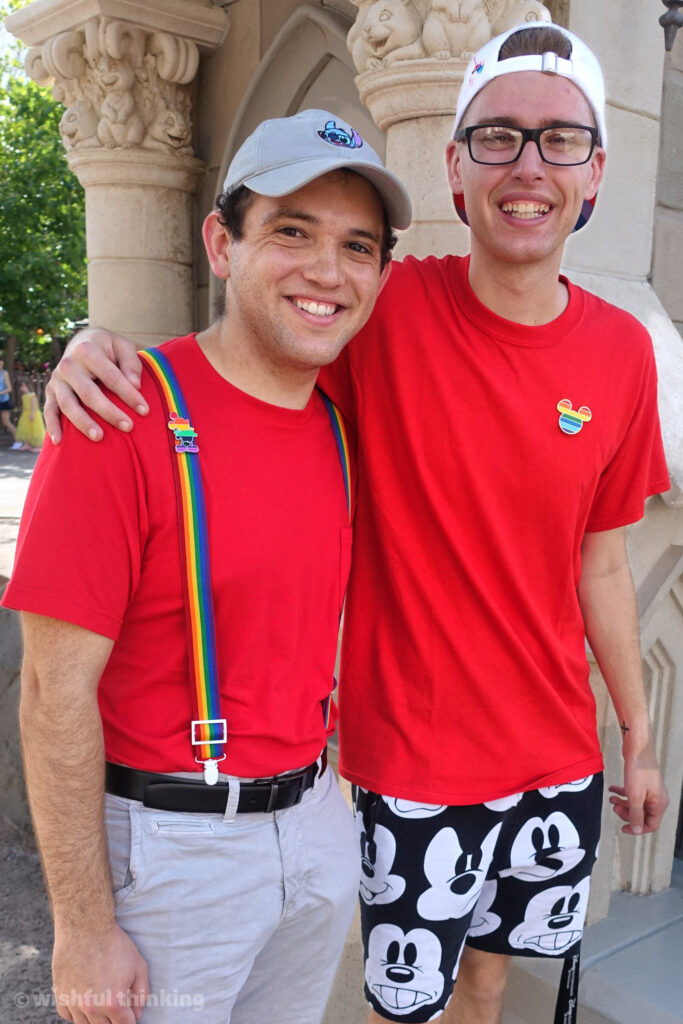 Two gay men hug at the Magic Kingdom for Gay Days at Walt Disney World, celebrating LGBTQ+ pride