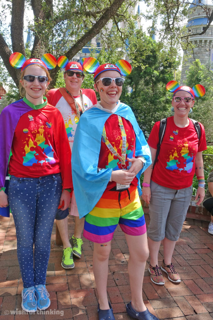 A family with a transgender teen visits from the midwest to celebate Gay Days at Magic Kingdom in Walt Disney World, dressed in rainbows, red-tshirts, and rainbow Mickey Mouse ears