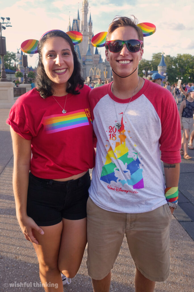 During Gay Days at Magic Kingdom, two friends hug in front of Cinderella Castle and pose on Main Street USA