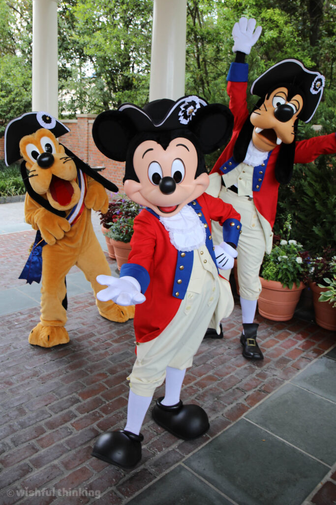 On the 4th of July, Pluto, Mickey and Goofy pose for Walt Disney World guests in fun tri-cornered hats and colonial American outfits