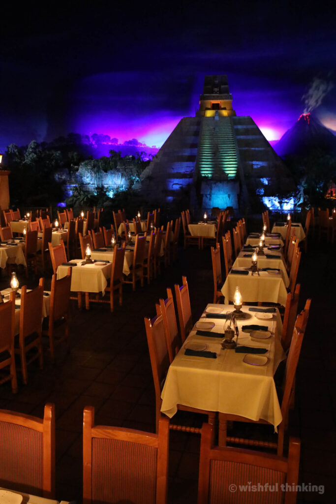 At EPCOT's Mexico pavilion, diners enjoy a cool indoor dimly lit restaurant in a pyramid, beside the water-launch of the boat ride with the Three Caballeros