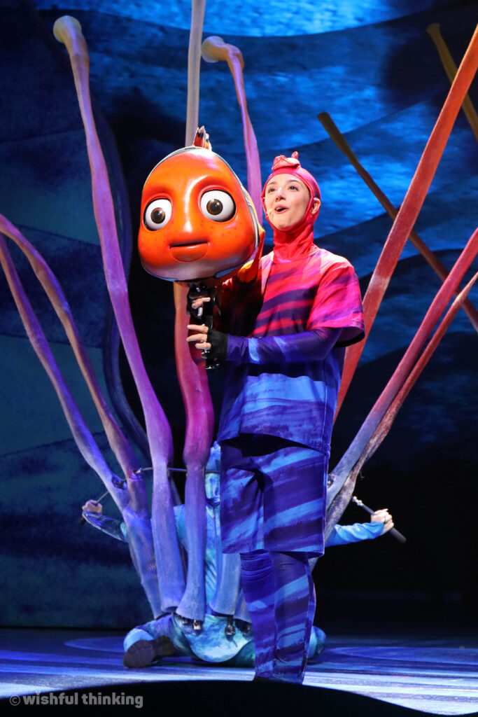 An orange Nemo puppet peers through an anemone from Finding Nemo - The Great Big Blue... and Beyond musical show at Disney's Animal Kingdom Park