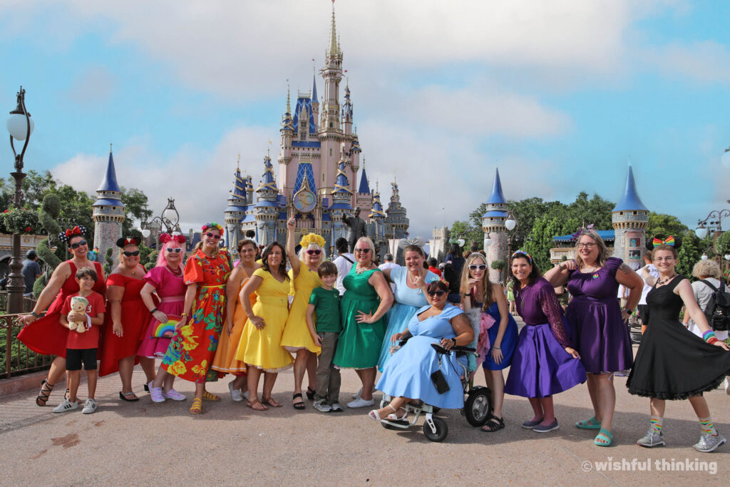 Women in dresses form a rainbow spectrum in the Cinderella Castle hub at Magic Kingdom during the annual Gay Days celebration in Orlando, Florida