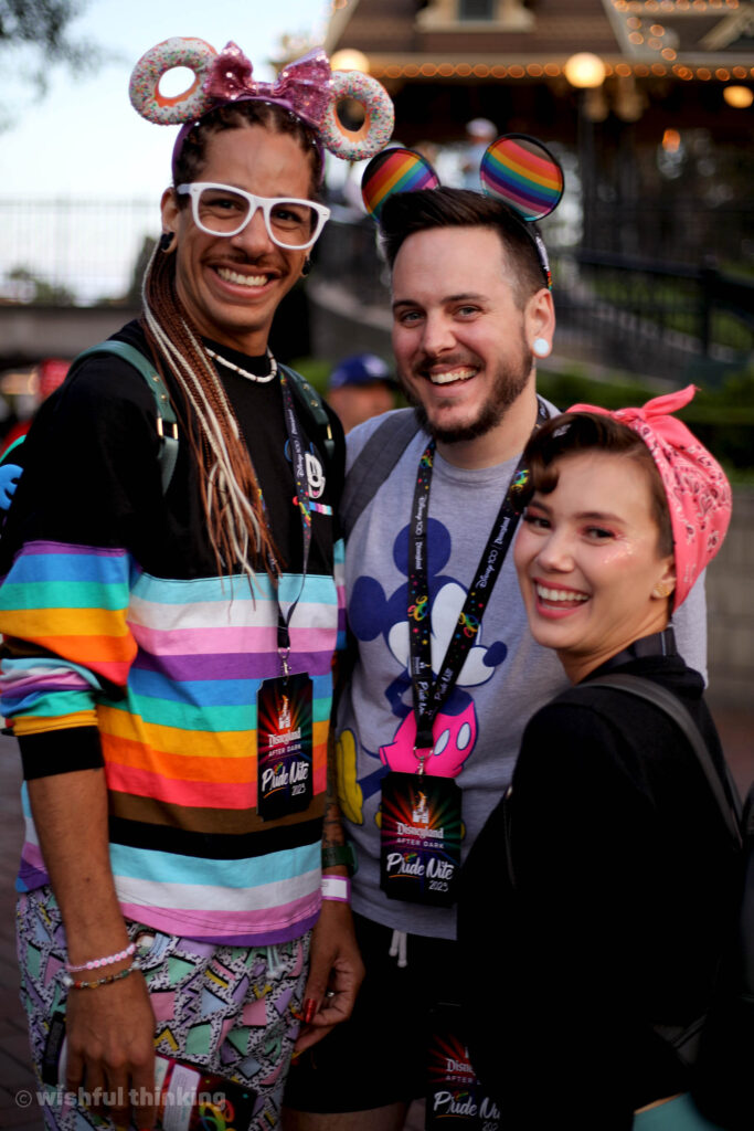 A trio of friends smile and hug during 2023's Disneyland After Dark Pride Nite party at the Disneyland Resort in Anaheim, California