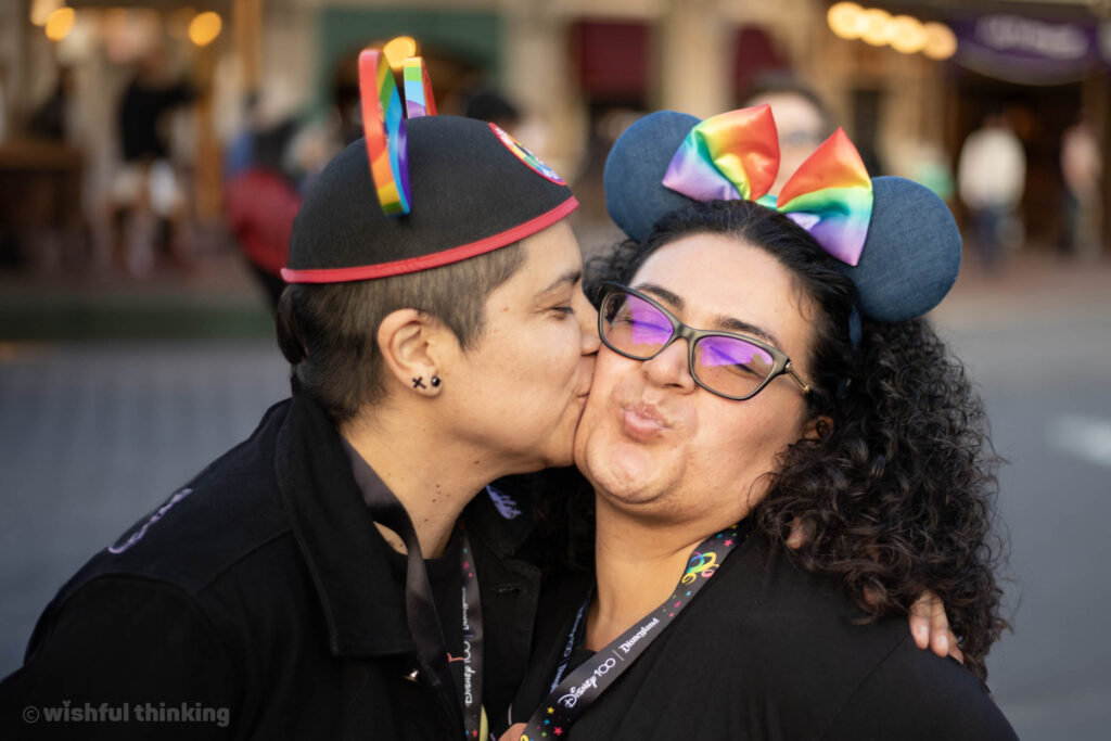 Two women exchange a sweet kiss on the cheek during the Disneyland After Dark Pride Nite event at Disneyland Resort in June, 2023