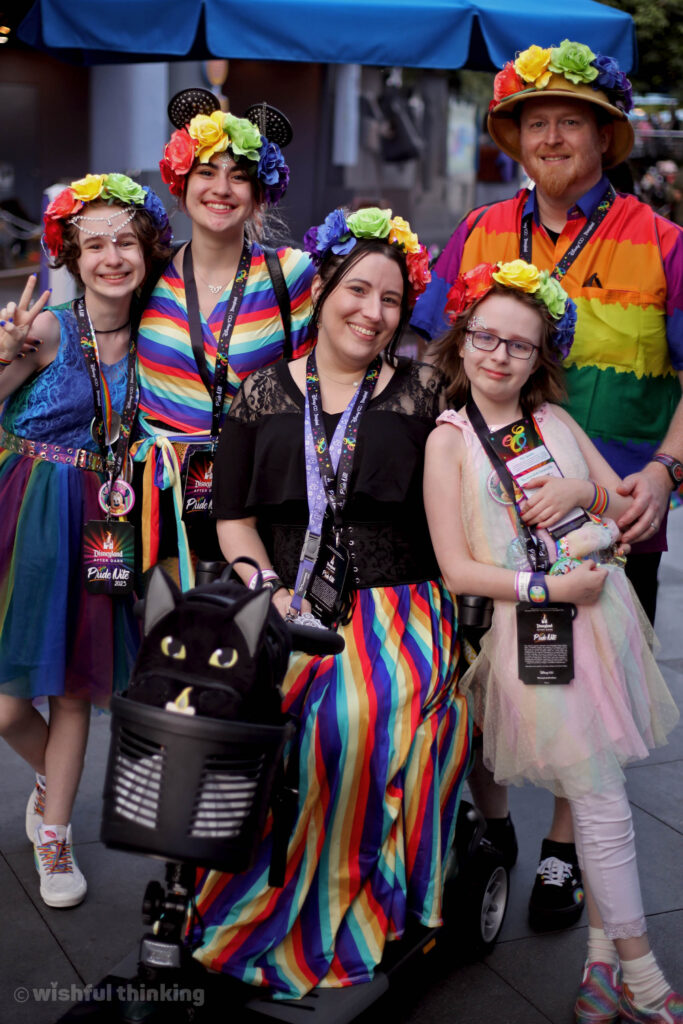 A close family, all dressed in rainbows, hugs and celebrates Pride month during Disneyland After Dark Pride Nite in June, 2023